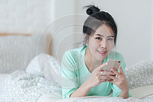 Young Asian woman taking selfie photo in bedroom