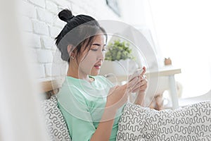 Young Asian woman taking selfie photo in bedroom