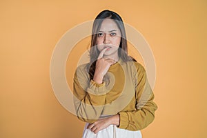 Young asian woman thinking something with bite finger gesture