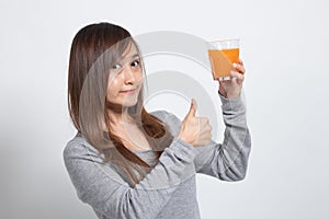 Young Asian woman thumbs up drink orange juice