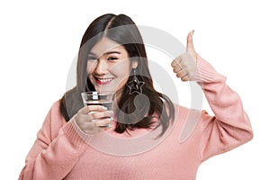 Young Asian woman thumbs up with a glass of drinking water.