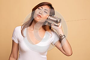 Young Asian woman with tin can phone