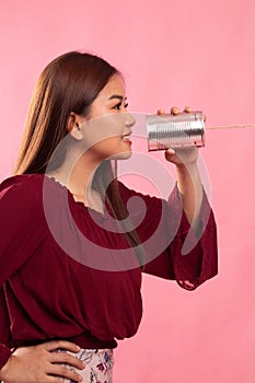 Young Asian woman with tin can phone