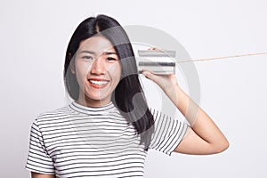 Young Asian woman with tin can phone