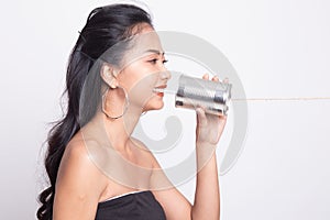 Young Asian woman with tin can phone