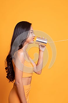 Young Asian woman with tin can phone