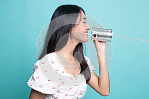 Young Asian woman with tin can phone