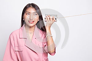 Young Asian woman with tin can phone