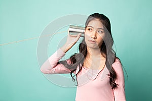 Young Asian woman with tin can phone