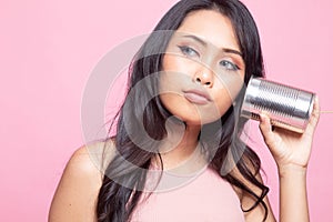 Young Asian woman with tin can phone