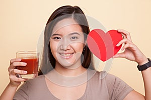 Young Asian woman with tomato juice and red heart.