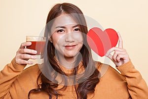 Young Asian woman with tomato juice and red heart.