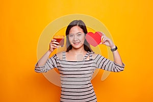 Young Asian woman with tomato juice and red heart.