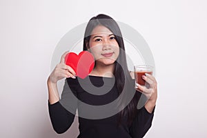 Young Asian woman with tomato juice and red heart.