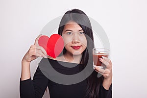 Young Asian woman with tomato juice and red heart.