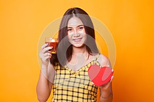 Young Asian woman with tomato juice and red heart.