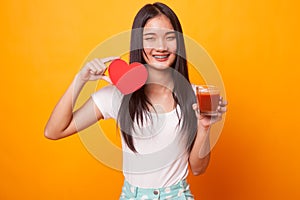 Young Asian woman with tomato juice and red heart.