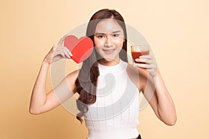 Young Asian woman with tomato juice and red heart