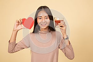 Young Asian woman with tomato juice and red heart