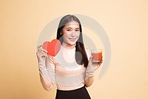 Young Asian woman with tomato juice and red heart