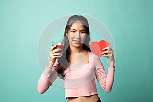 Young Asian woman with tomato juice and red heart