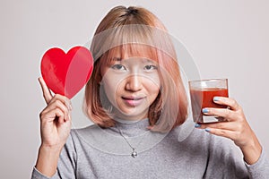 Young Asian woman with tomato juice and red heart.