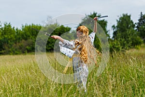 Young asian woman in traditional kimono trains fighting techniques with katana sword