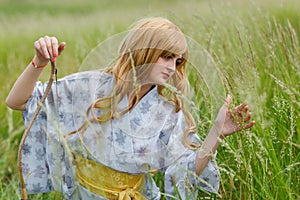 Young asian woman in traditional kimono trains fighting techniques with Samurai Bow