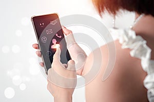 A young Asian woman uses her right hand to hold a mobile phone with a black screen (focus) photo