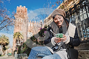 Young asian woman using a cellphone app for texting messages in a social media. Cheerful chinese girl smiling sitting