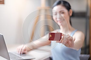 Young Asian woman using credit card for online shopping in at home, online shopping with computer laptop, technology