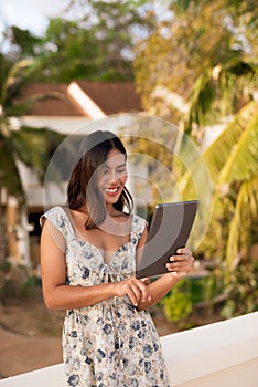 Young woman using tablet computer outdoors during summer