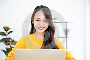 Young asian woman using laptop at house. Work at home