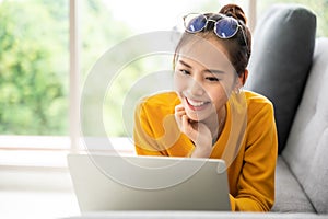 Young asian woman using laptop at house. Work at home