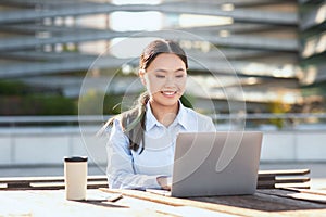 Young Asian Woman Using Laptop at Table