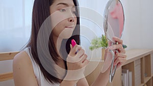 Young Asian woman using lipstick make up in front mirror, Happy female using beauty cosmetics to improve herself ready to working