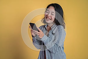 Young asian woman using mobile cell phone typing sms message