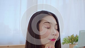 Young Asian woman using powder make up in front mirror, Happy female using beauty cosmetics to improve herself ready to working in