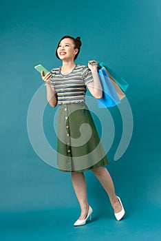 Young Asian woman using a smart phone shopping online and smiling