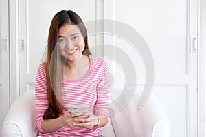 Young asian woman using smart phone with smiling, happy and relax emotion in white room background, people on phone, lifestyle