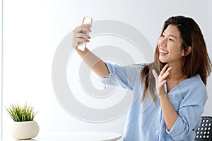Young asian woman using smartphone to selfie her portrait at home, poeple and technology, lifestyle