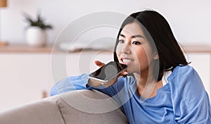 Young asian woman using voice assistant on smartphone