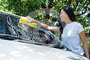Young Asian woman washing cars at home on vacation