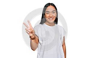 Young asian woman wearing casual white t shirt showing and pointing up with fingers number two while smiling confident and happy