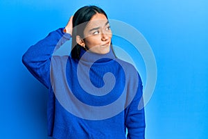Young asian woman wearing casual winter sweater confuse and wondering about question