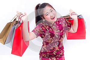 Young asian woman wearing chinese dress traditional cheongsam with Carrying a shopping bag and smile. Chinese New Year