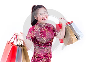 Young asian woman wearing chinese dress traditional cheongsam with Carrying a shopping bag and smile.