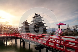 Young asian woman wearing Kimono Japanese tradition dressed sightseeing at Matsumoto Castle during cherry blossom Sakura is one