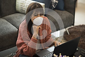 Young Asian woman wearing medical mask working on laptop during remotely work at home.