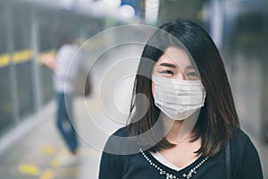 Young asian woman wearing protective face mask in subway due to the polluted air or pm 2.5 and Coronavirus disease or COVID-19